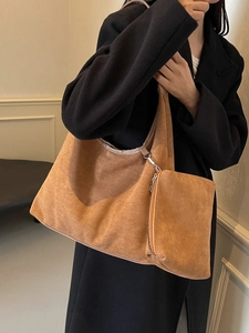 Grand sac cabas en suède marron avec pochette zippée assortie porté par un mannequin