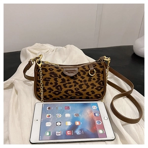Macro detail of leopard print bag with gold chain and brand logo leather tag