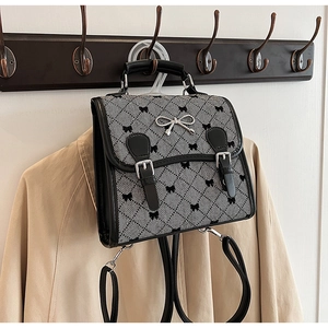 Detail of vintage plaid backpack with silver bow buckle and butterfly patterns