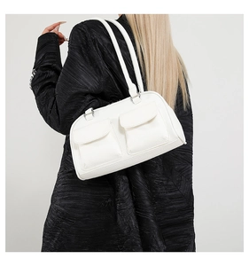 Detail of white lychee leather shoulder bag with two front flap pockets on a model