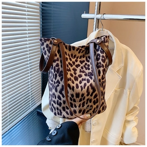 Detail of leopard print velvet bucket bag with brown leather straps and gold logo