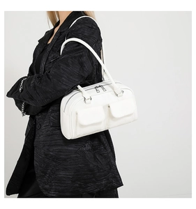 Detail view of a white vintage leather shoulder bag with two front pockets and double zippers