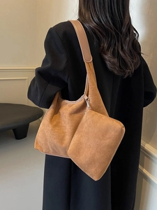 Sac hobo en suédine marron avec petite pochette zippée porté par un mannequin