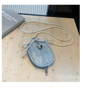Détail du mini sac en denim avec bandoulière en perles et pendentif en forme de cœur