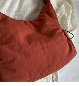 Detail van de lichte terracotta nylon stof en de gladde metalen rits van de tas