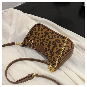 Detailed close-up of leopard print shoulder bag with gold chain and leather trim