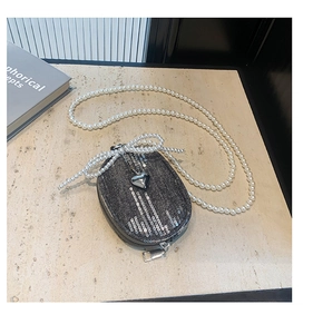 Détail du mini sac en denim avec pendentif cœur argenté et nœud en chaîne perlée