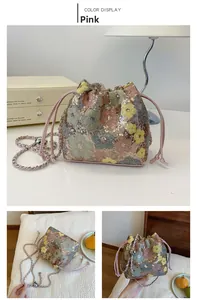 Dettaglio della borsa a secchiello con paillettes floreali e tracolla a catena metallica