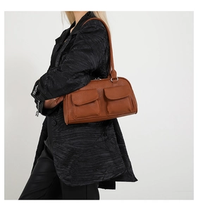Detailed texture of caramel brown grainy leather shoulder bag with silver hardware accents