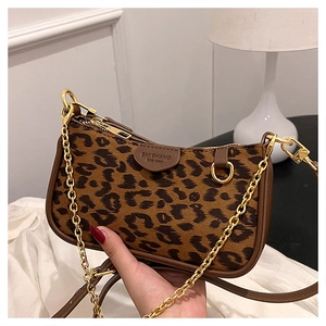 Detail of leopard print handbag with golden chain strap and leather embossed logo plate
