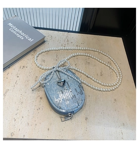 Détail du mini sac bandoulière en denim bleu avec paillettes et chaîne en perles