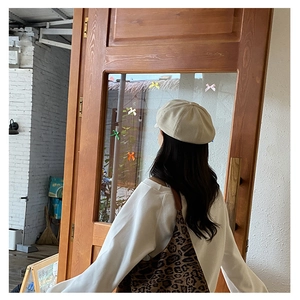 Detail of trendy leopard print tote bag paired with a beige knit beret and casual sweatshirt
