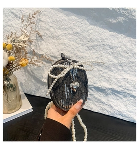 Détail du mini sac en denim avec paillettes, pendentif cœur et chaîne en perles
