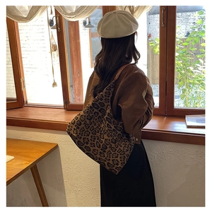 Spacious leopard print tote bag shown on a model in a cozy sunlit room