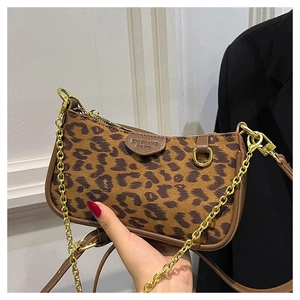 Close-up of leopard print shoulder bag with gold chain strap and brown leather details