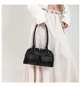 Close-up of black leather Boston style shoulder bag with symmetric pockets and silver hardware