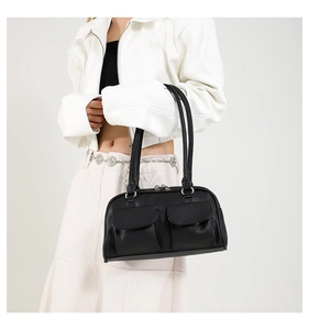 Detail of a black vintage underarm bag with front pockets and smooth leather texture