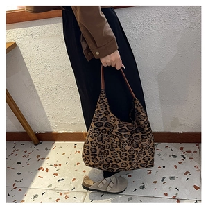 Close-up of leopard print canvas tote bag with leather strap and vintage texture