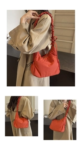 Detail van de oranje cloud bag met trekkoord en een brede schouderband met rimpels