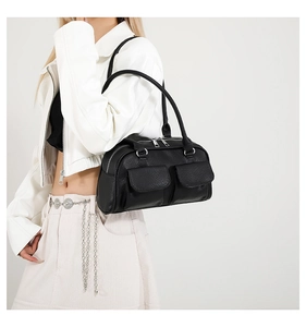 Detail of black lychee grain shoulder bag featuring flap pockets and silver metal zippers