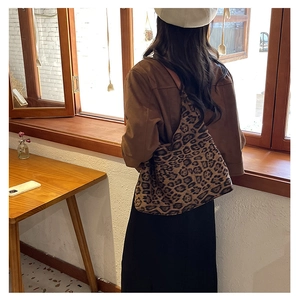 Detail of vintage leopard print tote bag featuring canvas texture and wide shoulder strap
