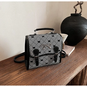 Detail of vintage rhombic pattern backpack with bow decorations and metal accents