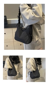 Detail van zwarte gewatteerde nylon tas met gerimpelde band en zijtrekkoordje