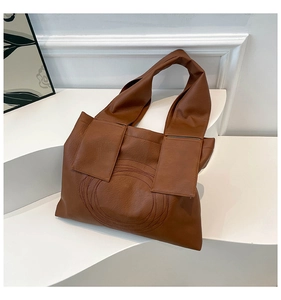 Detailed view of the brown PU leather tote bag featuring unique circular stitched patterns