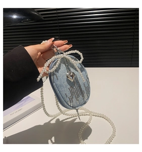 Détail du porte-monnaie en denim avec sequins argentés, perles et breloque en cœur
