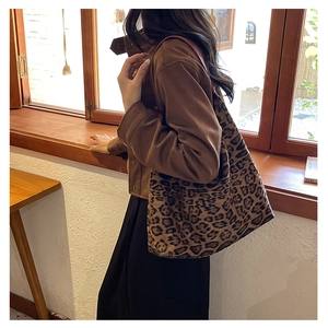 Leopard print tote bag with brown leather straps styled for autumn fashion on a model