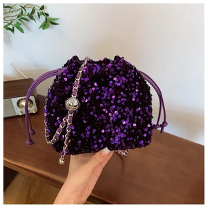 Dettaglio borsa a secchiello con paillettes viola e tracolla a catena in metallo