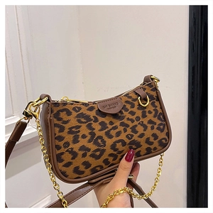 Detail of leopard print handbag with golden chain and leather trim brand plate