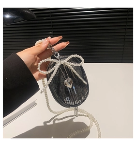 Détail du porte-monnaie en denim avec paillettes, chaîne perles et pendentif cœur