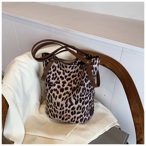 Close-up of leopard print bucket bag with leather handles and gold brand logo