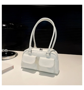Detail of white leather shoulder bag featuring cargo pockets and silver metal zipper