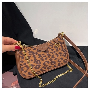 Detail of leopard print shoulder bag with brown leather trim and gold chain strap