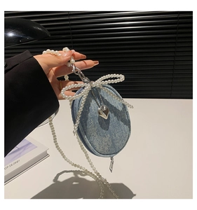 Détail du mini sac en jean avec grand nœud en perles et pendentif en forme de cœur