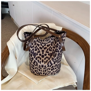 Close-up of leopard print bucket bag with magnetic closure and brown leather straps