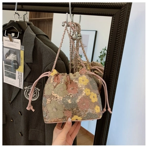 Dettaglio borsa a secchiello con paillettes floreali e finiture in pelle rosa
