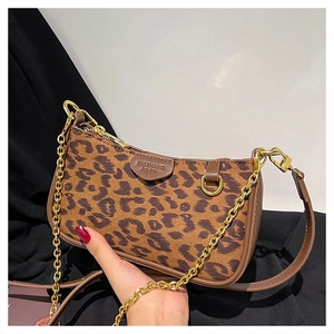 Close-up of leopard print shoulder bag with gold chain and embossed leather detail