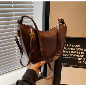 Detailed macro of dark brown hobo bag featuring glossy PU leather and gold buckle