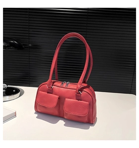 Detail view of red faux leather shoulder bag featuring textured finish and twin flap pockets
