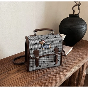 Detail of dachshund embroidery on houndstooth fabric with premium brown leather trim