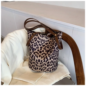 Detail of leopard print bucket bag with dark brown leather handles and golden studs