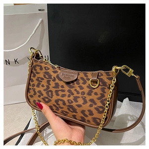 Detail of retro leopard print handbag featuring velvet texture and dark brown leather trim