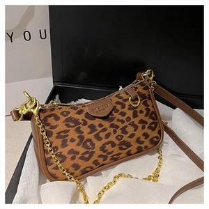 Close-up of leopard print crossbody bag with gold chain and dark brown leather trim