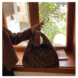Detailed view of leopard print tote bag with large capacity in natural sunlight setting