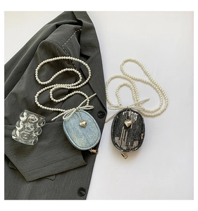 Détail de mini sacs bandoulière avec chaîne en perles et pendentif coeur élégant