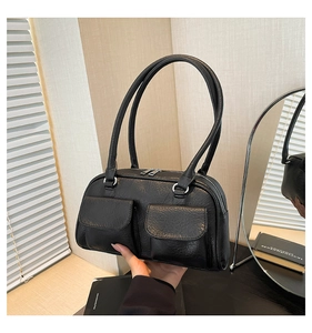 Detail of black vintage underarm bag with lychee grain texture and front flap pockets