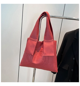 Detail of watermelon red tote bag showing wide shoulder strap and circular stitching